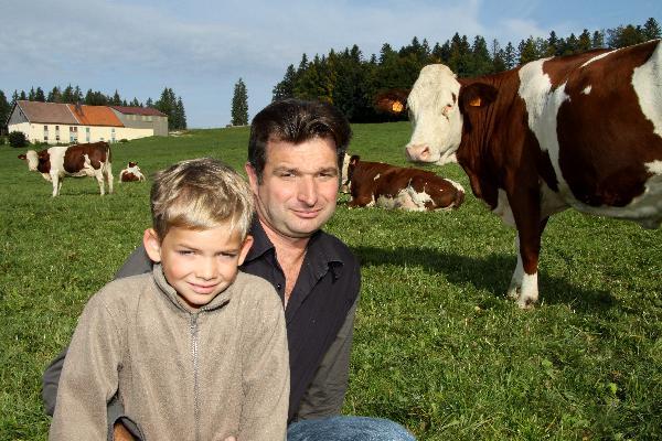 Fabrice Cuenot, ici avec Noa l'un de ses trois garçons, a choisi un chemin un peu différent de l'élevage traditionnel tout en restant attaché à la filière Comté.